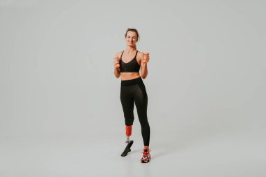 Ampütasyonu olan güzel bir genç kadın - güzel ve kendine güveni tam bir kadın, bacağı sakat, vücudunu mahcup eden bir kadına poz veriyor.