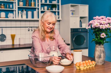 Güzel bir son sınıf öğrencisi mutfakta yemek pişiriyor. Büyükanne evde tatlı hazırlıyor. Yemek pişirme, yemek pişirme ve sağlıklı beslenme kavramları var.