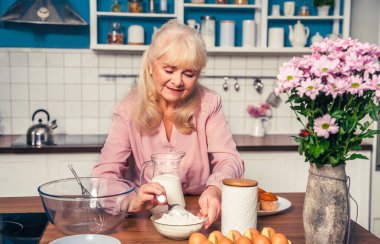 Güzel bir son sınıf öğrencisi mutfakta yemek pişiriyor. Büyükanne evde tatlı hazırlıyor. Yemek pişirme, yemek pişirme ve sağlıklı beslenme kavramları var.