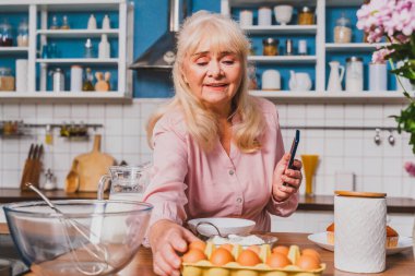 Güzel bir son sınıf öğrencisi mutfakta yemek pişiriyor. Büyükanne evde tatlı hazırlıyor. Yemek pişirme, yemek pişirme ve sağlıklı beslenme kavramları var.