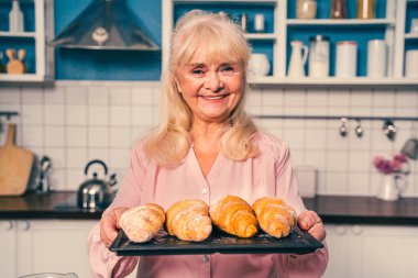 Güzel bir son sınıf öğrencisi mutfakta yemek pişiriyor. Büyükanne evde tatlı hazırlıyor. Yemek pişirme, yemek pişirme ve sağlıklı beslenme kavramları var.