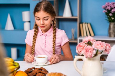 Güzel bir kız sabah kahvaltısını evde yapıyor güzel bir genç kız evdeki mutfak masasında yemek yiyor, aile hayatı anları yaşıyor.