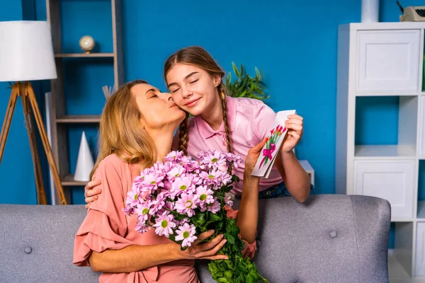 Female child presenting flowers to her mom at home, happy domestic life moments - Family having fun, concepts about elderly, mult-generation family and relationship