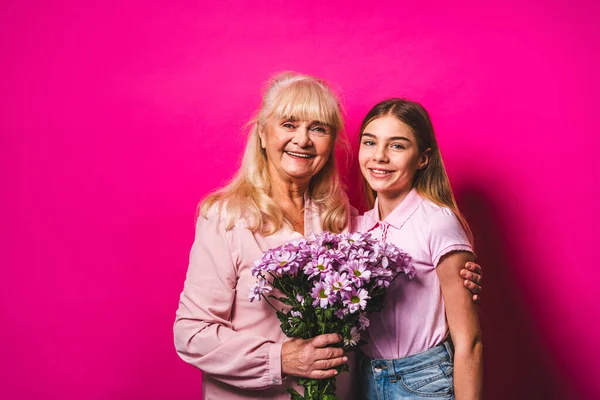 Grandchild presenting flowers to granny at home, happy domestic life moments - Family having fun, concepts about elderly, mult-generation family and relationship