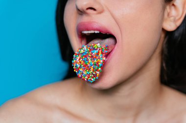 Dilinde renkli şekerlemeler olan bir dişinin sanatsal görüntüsü.