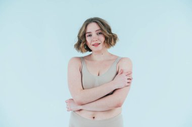 Stüdyoda poz veren güzel bir kadın resmi. Vücut pozitifliği ve kendini kabullenme kavramı