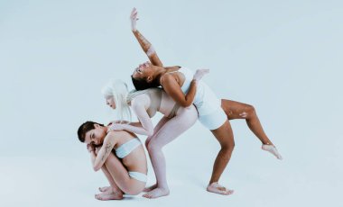 Farklı tür ten rengine sahip çok ırklı bir grup kadın stüdyoda birlikte poz veriyor. Vücut pozitifliği ve kendini kabullenme kavramı