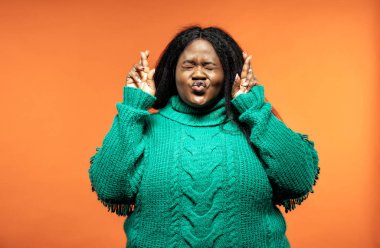 Renkli bir arka planda günlük kıyafetlerle poz veren güzel bir kadın.