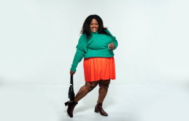 Beyaz arka planda günlük giysiler içinde poz veren güzel bir kadın.