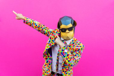 Renkli arka planda komik düşük polyester maskeli mutlu bir adam reklamcılık için yaratıcı kavramsal bir fikir düşük poligami kağıt maskeli bir yetişkin komik pozlar veriyor.