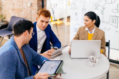 Proje yöneticileri ve çalışanları fikir üretmek için beyin fırtınası yapıyorlar - çok ırklı işçi grubu yeni açılan bir ofiste iş toplantısı yapıyor