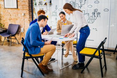 Proje yöneticileri ve çalışanları fikir üretmek için beyin fırtınası yapıyorlar - çok ırklı işçi grubu yeni açılan bir ofiste iş toplantısı yapıyor