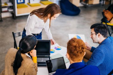 Proje yöneticileri ve çalışanları fikir üretmek için beyin fırtınası yapıyorlar - çok ırklı işçi grubu yeni açılan bir ofiste iş toplantısı yapıyor