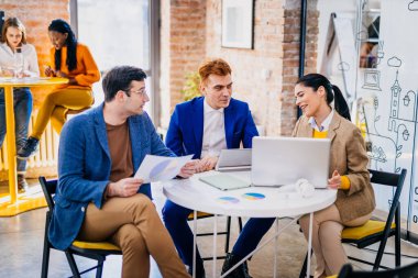Proje yöneticileri ve çalışanları fikir üretmek için beyin fırtınası yapıyorlar - çok ırklı işçi grubu yeni açılan bir ofiste iş toplantısı yapıyor