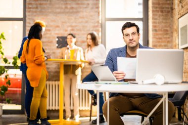 Proje yöneticileri ve çalışanları fikir üretmek için beyin fırtınası yapıyorlar - çok ırklı işçi grubu yeni açılan bir ofiste iş toplantısı yapıyor