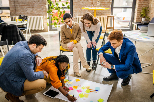 Project managers and employees brainstorming on ideas - Multi-ethnic group of workers having business meeting in a start-up office