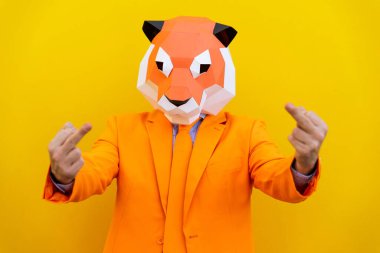 3 boyutlu origami maskeli havalı bir adam şık renkli kıyafetler giyiyor. Reklamcılık için yaratıcı bir konsept, renkli arka planda komik şeyler yapan hayvan kafası maskesi.