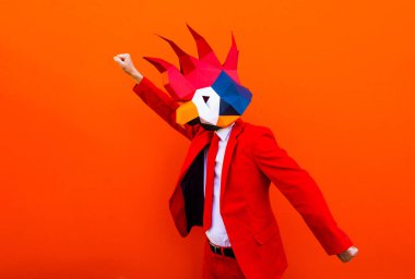 3 boyutlu origami maskeli havalı bir adam şık renkli kıyafetler giyiyor. Reklamcılık için yaratıcı bir konsept, renkli arka planda komik şeyler yapan hayvan kafası maskesi.