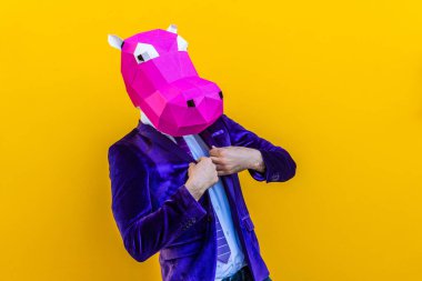 3 boyutlu origami maskeli havalı bir adam şık renkli kıyafetler giyiyor. Reklamcılık için yaratıcı bir konsept, renkli arka planda komik şeyler yapan hayvan kafası maskesi.