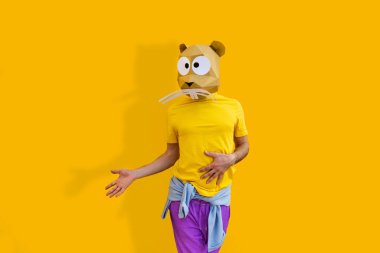 3 boyutlu origami maskeli havalı bir adam şık renkli kıyafetler giyiyor. Reklamcılık için yaratıcı bir konsept, renkli arka planda komik şeyler yapan hayvan kafası maskesi.