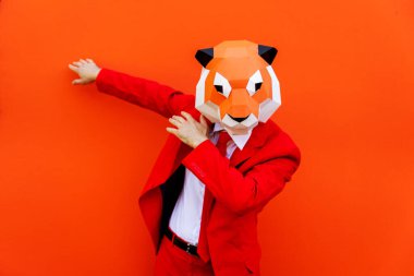 3 boyutlu origami maskeli havalı bir adam şık renkli kıyafetler giyiyor. Reklamcılık için yaratıcı bir konsept, renkli arka planda komik şeyler yapan hayvan kafası maskesi.
