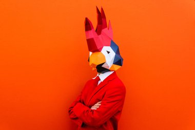 3 boyutlu origami maskeli havalı bir adam şık renkli kıyafetler giyiyor. Reklamcılık için yaratıcı bir konsept, renkli arka planda komik şeyler yapan hayvan kafası maskesi.