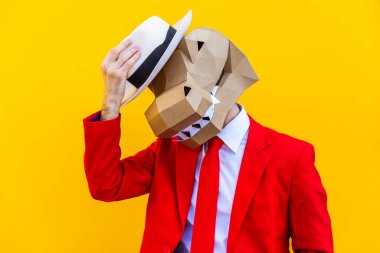 3 boyutlu origami maskeli havalı bir adam şık renkli kıyafetler giyiyor. Reklamcılık için yaratıcı bir konsept, renkli arka planda komik şeyler yapan hayvan kafası maskesi.