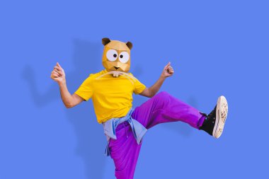 3 boyutlu origami maskeli havalı bir adam şık renkli kıyafetler giyiyor. Reklamcılık için yaratıcı bir konsept, renkli arka planda komik şeyler yapan hayvan kafası maskesi.