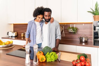 Güzel Afro-Amerikan çifti evde yemek pişiriyor güzel ve neşeli siyah çift mutfakta birlikte yemek hazırlıyor.
