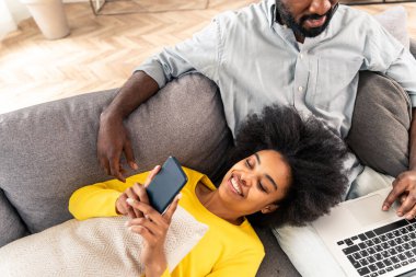 Bilgisayar dizüstü bilgisayarı üzerinde çalışan güzel Afro-Amerikalı çift modern çiftler online alışveriş yapıyor.