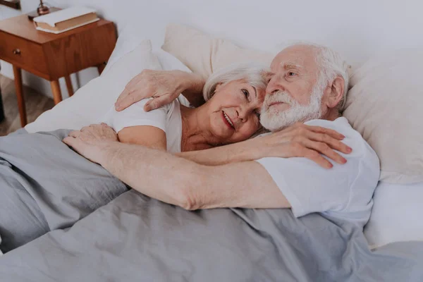 美しい高齢者のカップルは自宅で一緒に時間を楽しむ 自宅でロマンチックな瞬間 自宅でベッドで高齢者のカップル — ストック写真