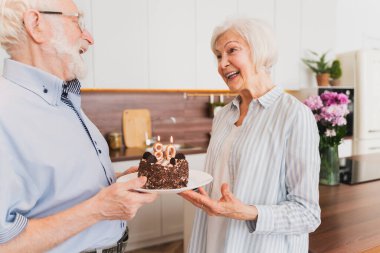 Güzel bir son sınıf çifti doğum günü pastasıyla kutlama yapıyor.