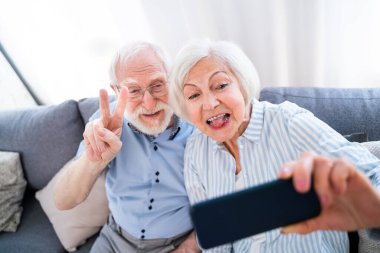 Mutlu son sınıf çifti cep telefonuyla fotoğraf çekiyor sosyal ağlarda paylaşmak için - modern teknoloji kullanan yaşlı insanlar, selfie çeken dedeler