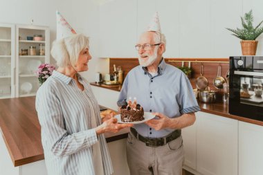 Güzel bir son sınıf çifti doğum günü pastasıyla kutlama yapıyor.