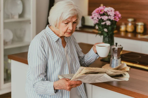 Старшая Женщина Отдыхает Дома Читает Газеты Завтракает — стоковое фото