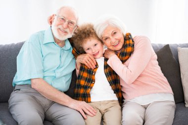 Büyükbaba ve torun evde oynuyorlar. Aile evde, büyükanne ve büyükbaba yeğenlerine bakıyor.