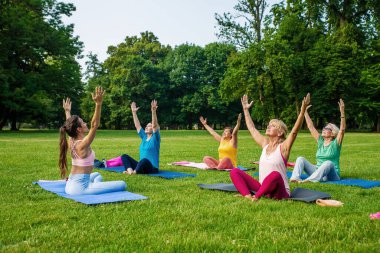 Parkta fitness eğitmeniyle eğitim gören çok ırklı yaşlı kadınlar grubu - aktif yaşlılar spor yapıyor.