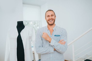 Elbise tasarımcısı, tekstil fabrikasında bir giyim markası üzerinde çalışan moda tasarımcısı için yeni bir tasarım yapıyor.