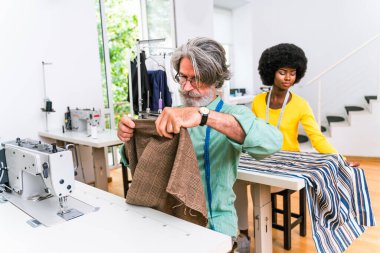 Bir giyim atölyesinde çalışan çok ırklı moda tasarımcıları takımı - çok ırklı stilistler, terzi tasarımcılar ve terziler yeni bir koleksiyonda çalışıyorlar