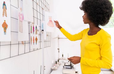 Moda tasarımcısı bir giyim atölyesinde çalışıyor. Yeni bir koleksiyon terzisi üzerinde çalışıyor.