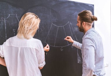 Bir giyim atölyesinde çalışan çok ırklı moda tasarımcıları takımı - çok ırklı stilistler, terzi tasarımcılar ve terziler yeni bir koleksiyonda çalışıyorlar
