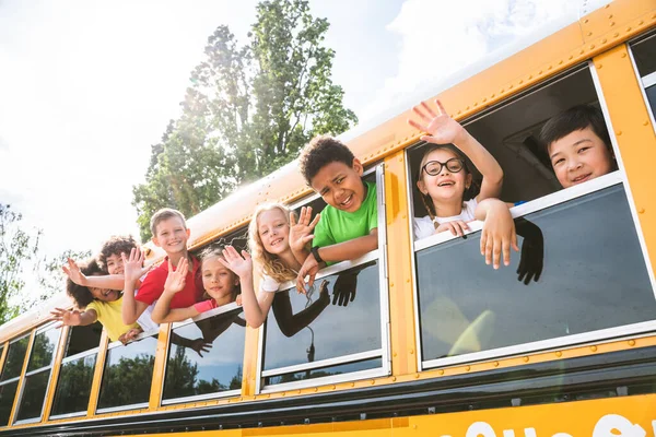 버스를 다니는 일단의 학생들 초등학생들은 재미있게 — 스톡 사진