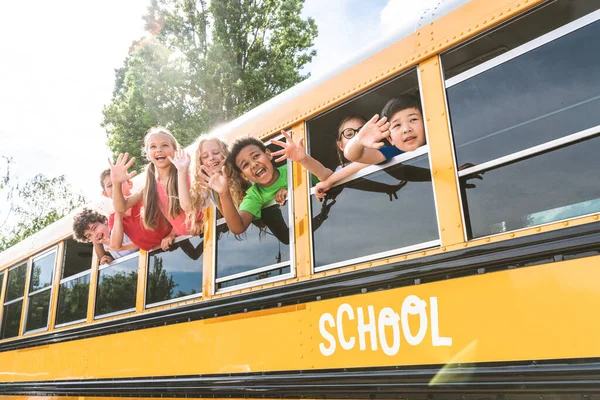 乘黄色校车上学的小学生小组 小学生玩得很开心 — 图库照片
