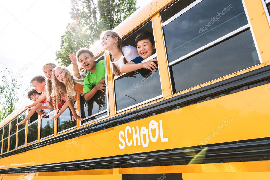 Group of young students attending primary school on a yellow school bus - Elementary school kids ha1ving fun