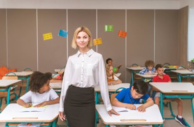 İlkokuldaki çok ırklı çocuklar, okul ve sınıf arkadaşlarıyla eğlenen eğlenceli öğrenciler.