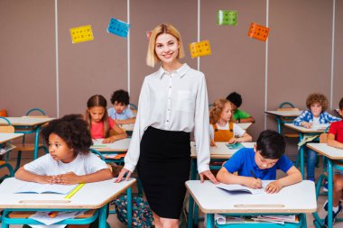 İlkokuldaki çok ırklı çocuklar, okul ve sınıf arkadaşlarıyla eğlenen eğlenceli öğrenciler.