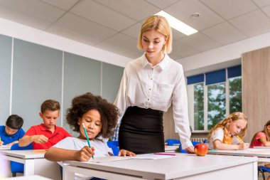 İlkokuldaki çok ırklı çocuklar, okul ve sınıf arkadaşlarıyla eğlenen eğlenceli öğrenciler.