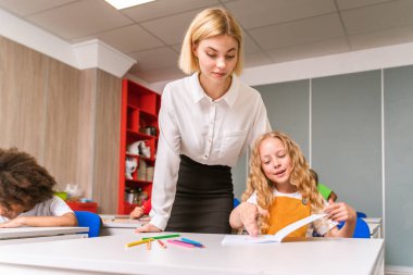 İlkokuldaki çok ırklı çocuklar, okul ve sınıf arkadaşlarıyla eğlenen eğlenceli öğrenciler.