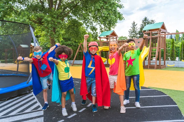 Grupo Multirracial Jóvenes Escolares Que Usan Disfraces Superhéroes Divierten Aire —  Fotos de Stock