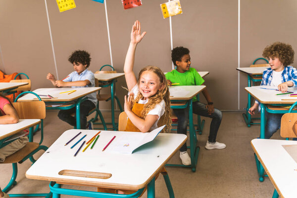 Multiracial group of kids at primary school - Playful schoolers enjoying school time and lesson with teacher and classmates